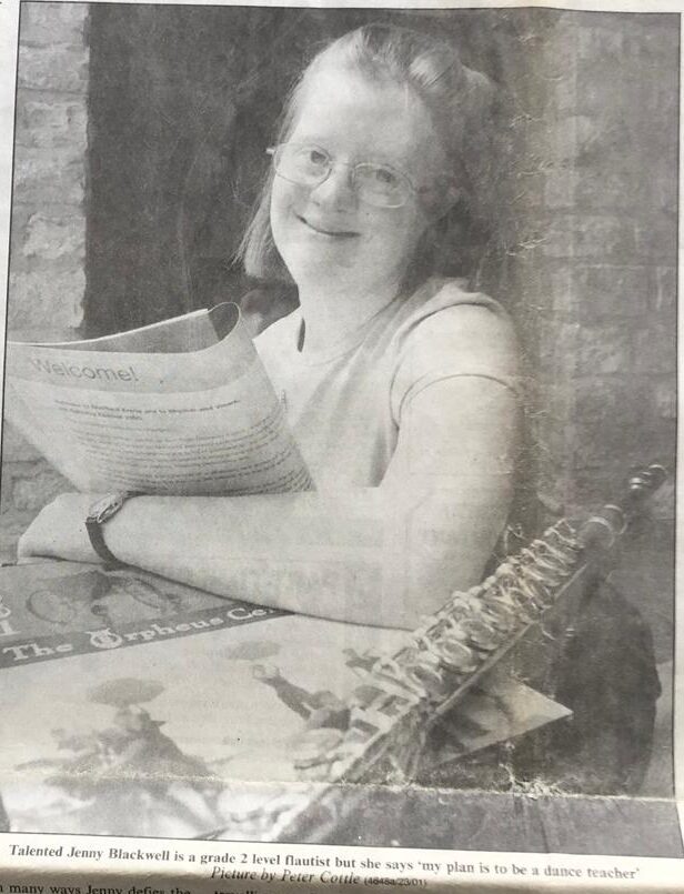 Girl with Down's syndrome holding music with a flute next to her