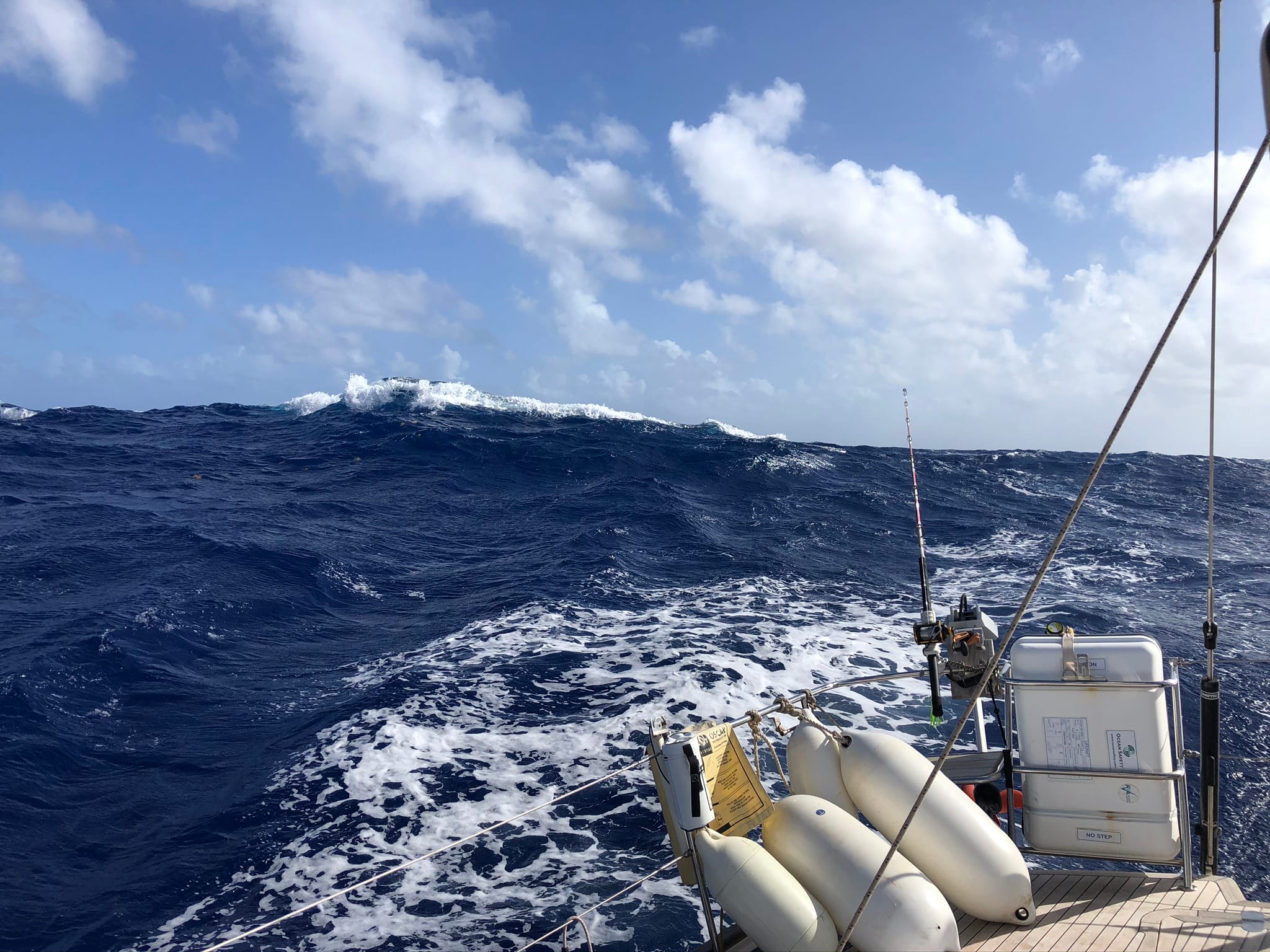 wave rising above the back of a yacht on the sea