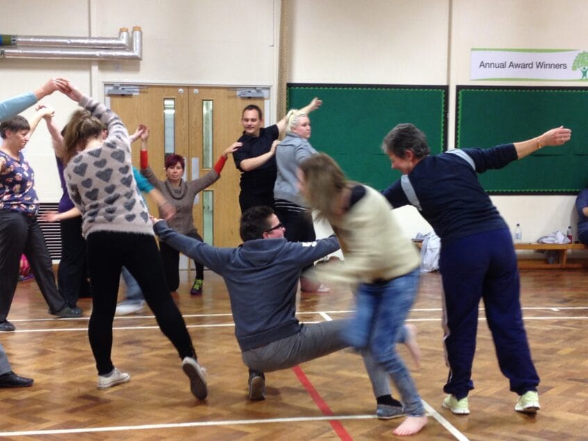 Dancers with and without learning disabilities dancing together in a hall